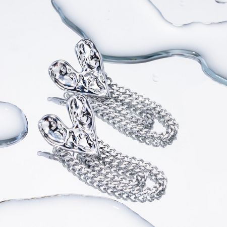 Close-up of a stylish silver chain earring with an abstract top piece.