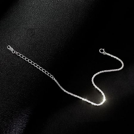 El brazalete de cadena de plata de ley 925 exhibido sobre un fondo oscuro.