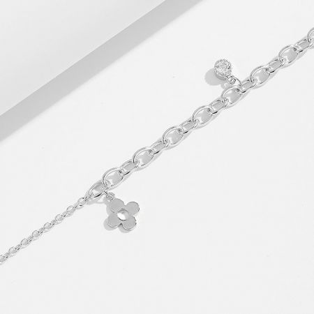 A silver chain bracelet featuring a decorative flower charm and a toggle clasp.