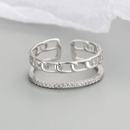 Close-up detail of the 925 silver rings, one with a chain-link pattern and the other with brilliant stones.