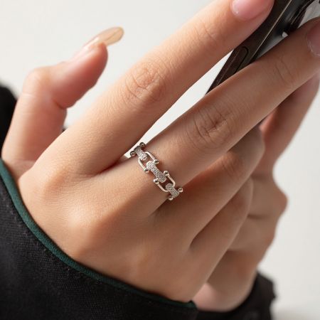 Bagues ajustables en chaîne U-link en argent 925 CZ. - Gros plan sur la bague ajustable en chaîne U-link en argent sterling 925 CZ sur le doigt d'un modèle, mettant en valeur les pierres scintillantes et le design de lien complexe.