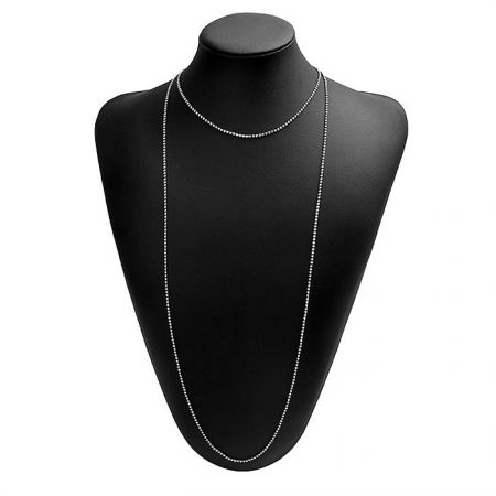 Die einfache lange Choker-Halskette, die auf einem schwarzen Schmuckbüsten präsentiert wird, um ihren Fall und Glanz zu zeigen.