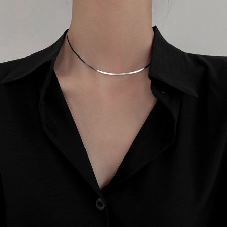 The sterling silver herringbone necklace styled as a choker, demonstrating its versatility.