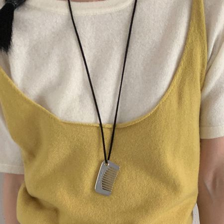 Korean Style Black Cord Necklace with Comb Pendant Minimalist Fashion Brass Jewelry Wholesale - A close-up of the Korean style black cord necklace featuring a unique, polished brass comb-shaped pendant on a white background.