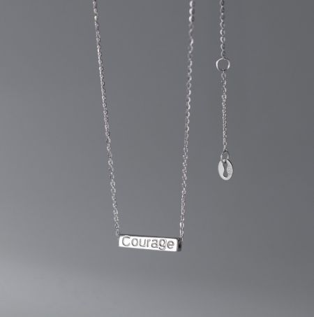 Collar de colgante grabable personalizado de plata esterlina 925. - Un primer plano de un collar de colgante de plata esterlina 925 con la palabra 'Coraje' grabada en una etiqueta rectangular, mostrando la opción de grabado personalizado.