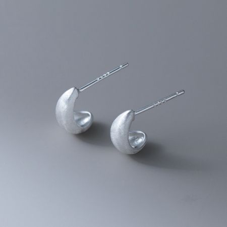 A pair of silver frosted curl stud earrings displayed on a clean white surface.