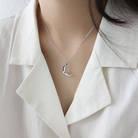 Modèle mettant en valeur l'ajustement élégant du collier en forme de croissant argenté.