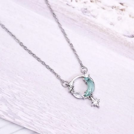 A sterling silver necklace featuring a delicate crescent moon and star charm.