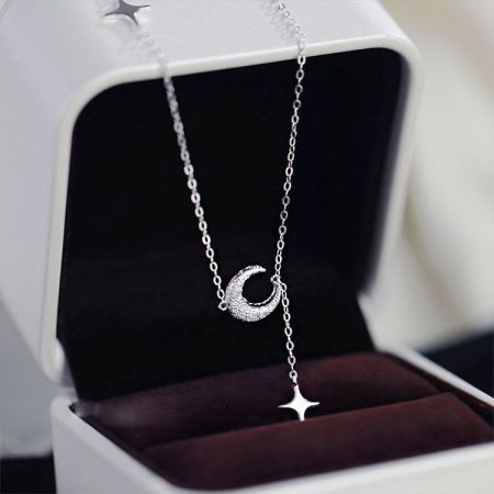 Collar de colgante de estrella con borlas de luna 925 - Un delicado collar de plata esterlina 925 con un colgante de luna creciente y estrella, elegantemente exhibido en una caja de joyería blanca.