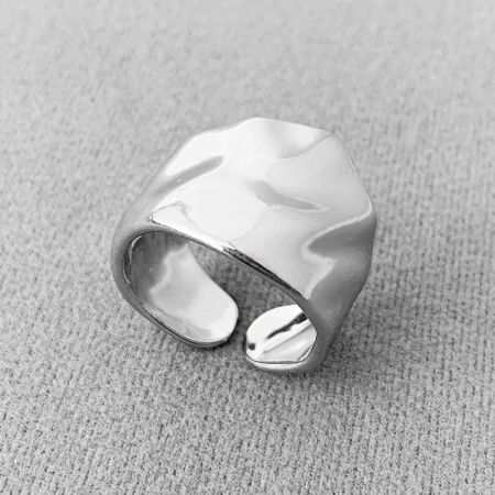 Close-up of a silver irregularly hammered wide band open ring.