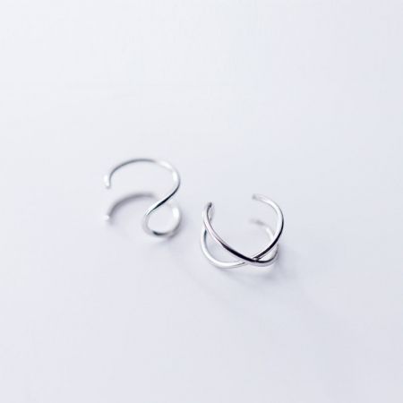 Scatto pulito del prodotto di un paio di orecchini a bracciale curvo in argento sterling 925.