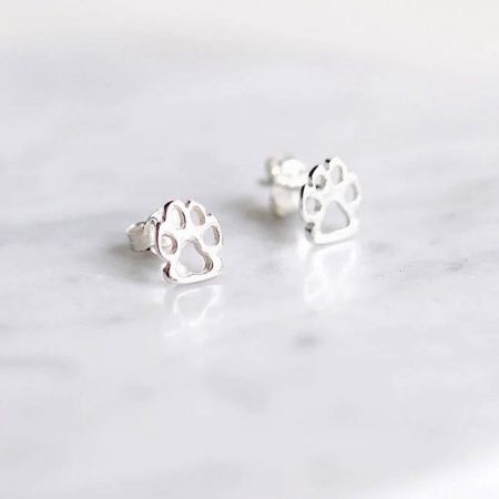 Orecchini a perno semplici in argento sterling 925 a forma di zampe di cane e gatto (set di 5 paia) - Un paio di orecchini a perno in argento sterling 925 a forma di impronte di zampe di cane, esposti su una superficie di marmo bianco.
