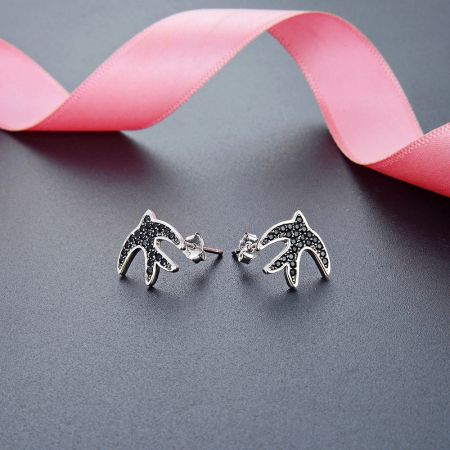 Boucles d'oreilles en forme d'hirondelle en argent sterling 925 avec zircon noir (5 paires) - Une paire de boucles d'oreilles en forme d'hirondelle en argent sterling 925, conçues avec des pierres en zircon noir scintillantes, présentées sur un fond blanc.
