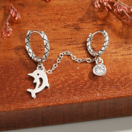Vista dettagliata dell'orecchino a forma di delfino in argento sterling con una pietra preziosa scintillante.