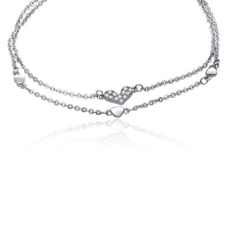 Detailed view of the heart charm with pave-set cubic zirconia on the double chain bracelet.