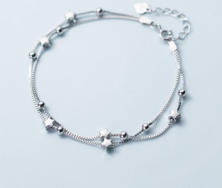 925 Sterling Zilveren Ster Bracelet - Een close-up van de 925 Sterling Zilveren Ster Bracelet, die het ontwerp met dubbele draad toont met delicate ster- en balcharms.