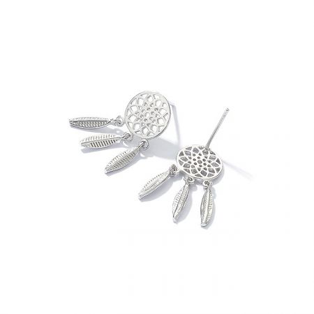 Prise de vue détaillée des boucles d'oreilles en argent de style attrape-rêves soulignant la finition polie et les charms en forme de plume.