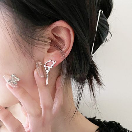 Un orecchino a goccia d'argento unico con design a frangia, che mostra l'estetica punk del set.