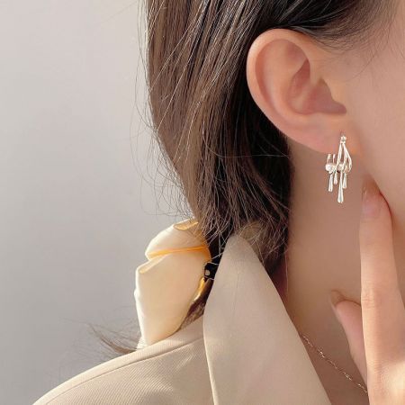 Modello che indossa gli orecchini a cerchio con goccia di perla in argento sterling, abbinati ad altri accessori di moda.
