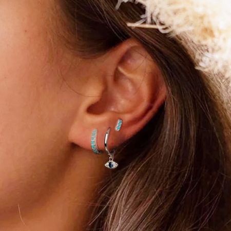 Close-up detail of the silver evil eye charm with a vibrant blue zircon gemstone.