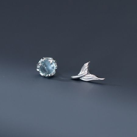 Vista dettagliata del set di orecchini a forma di coda di sirena in argento sterling, che mostra il chiodo in cristallo trasparente e il retro a chiusura a vite a forma di coda.