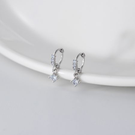 Modern sterling silver dangle earrings featuring clear geometric gemstones.