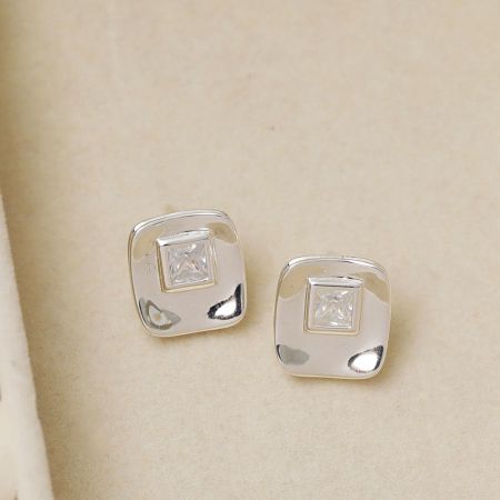 Otro ángulo de los versátiles pendientes de perno plateados con piedras cuadradas transparentes.
