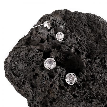 Productfoto van de sterling zilveren CZ stud oorbellen, weergegeven op een donkere, gestructureerde ondergrond.