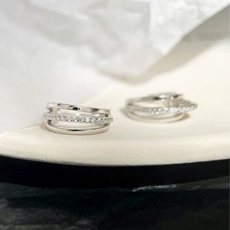 Una esposizione di due diversi paia di orecchini in argento sterling con impostazioni di gemme dettagliate.
