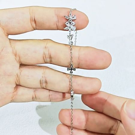 Primo piano della chiusura sicura e stilosa a forma di croce sul bracciale a fiore di sakura.