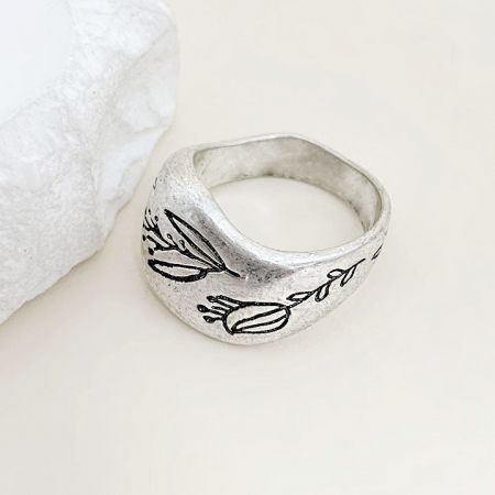 Close-up view of the silver ring's intricate floral engraving.