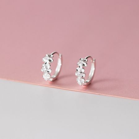 A pair of delicate camellia flower hoop earrings in 925 sterling silver, displayed on a neutral background.