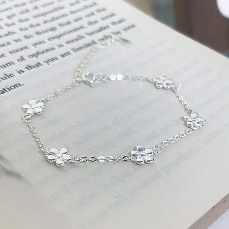 Toma detallada del producto de una pulsera de charm de flor de plata esterlina 925.