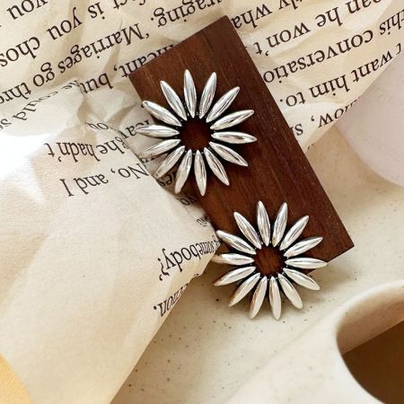 Un paio di orecchini a bottone a fiore di margherita cavi in argento sterling 925 dettagliati.