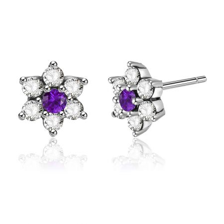 Gedetailleerd uitzicht op de bloemvormige zilveren oorbellen, met de centrale paarse en omringende witte cubic zirconia edelstenen.