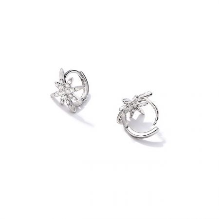 Une paire de boucles d'oreilles en argent en forme de fleur étoilée avec des pierres précieuses transparentes.
