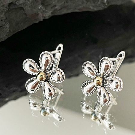 Een paar antieke bloemenoorbellen van 925 sterling zilver met gouden centra, weergegeven op een witte achtergrond.