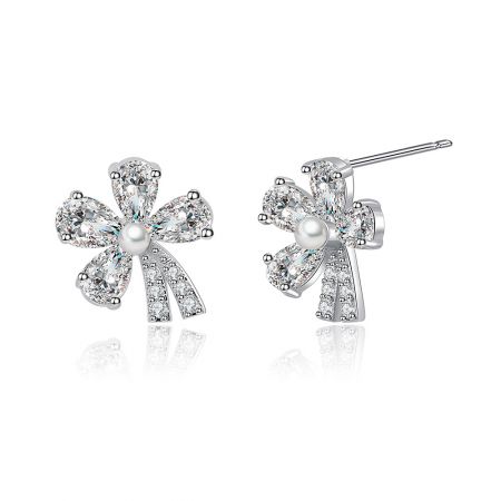 Perfil lateral de los pendientes de flor de plata, destacando el centro de perla y los intrincados detalles de piedras preciosas.