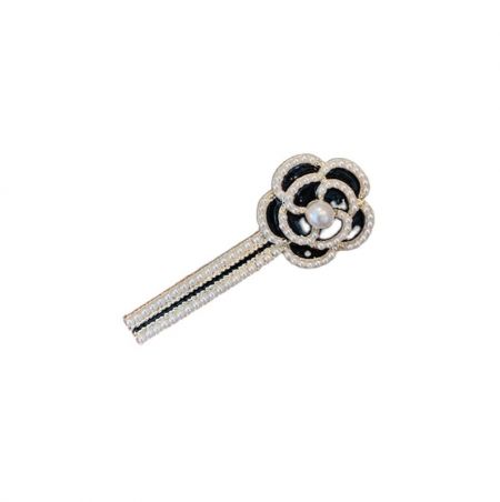 Elegant silver flower hair clip adorned with black and clear stones and a central pearl.