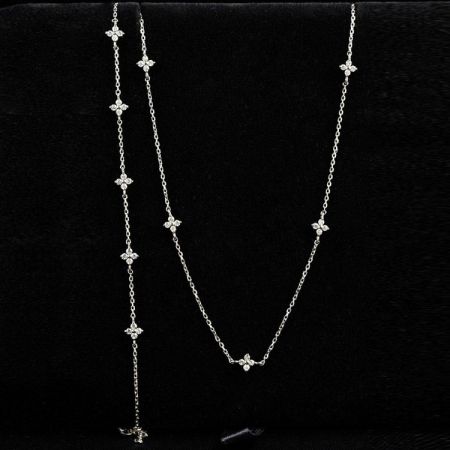 Collana con ciondolo a forma di fiore a 4 petali in zirconio 925. - Un modello che indossa una delicata collana in argento sterling 925 con un ciondolo a forma di fiore a 4 petali scintillante in zirconio.