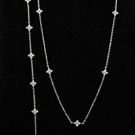 Vista detallada de un collar de plata en forma de flor con acentos de circonitas cúbicas brillantes.