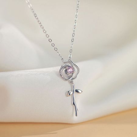 Detailed view of the silver flower pendant with its vibrant pink gemstone center.