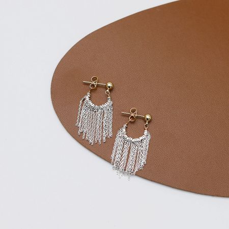 Gros plan des boucles d'oreilles à franges en argent, montrant les détails complexes des franges.
