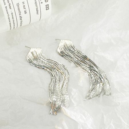 Dettaglio ravvicinato dell'orecchino a frangia in argento, evidenziando le intricate catene ondulate e frangiate in argento sterling.