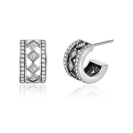 Schuin shot van de sterling zilveren studoorbellen, waarbij hun geometrisch patroon en briljante cubic zirconia worden benadrukt.