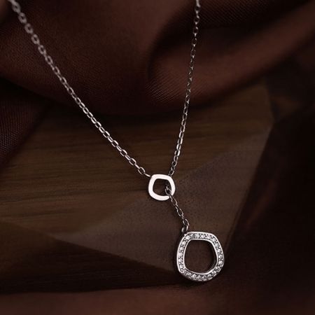 Mujer usando un collar de colgante geométrico de plata.