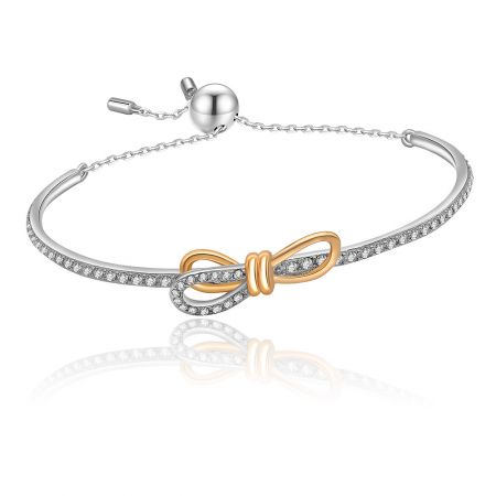 Detailed view of the Tied Ribbon Bow Bangle showcasing the intricate pave-set cubic zirconia on the silver and gold bow design.