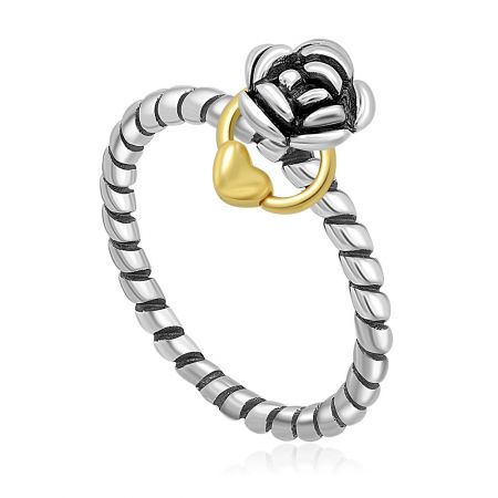 Gedetailleerd overzicht van de tweekleurige Rose Twist Band-ring met een delicate hartbedel.