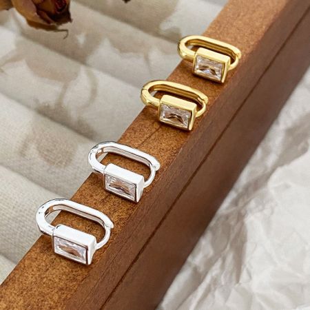 Orecchini a morsetto a forma di U in zirconia quadrata in argento sterling 925 (5 paia) - Una foto del prodotto degli orecchini vintage a morsetto a forma di U in argento sterling 925, disponibili in finiture sia argento che oro, con pietre di zirconia quadrate scintillanti.