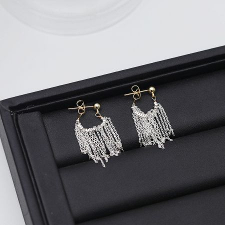 Vue latérale des boucles d'oreilles à franges en argent et or, mettant en avant le design en métaux mélangés.
